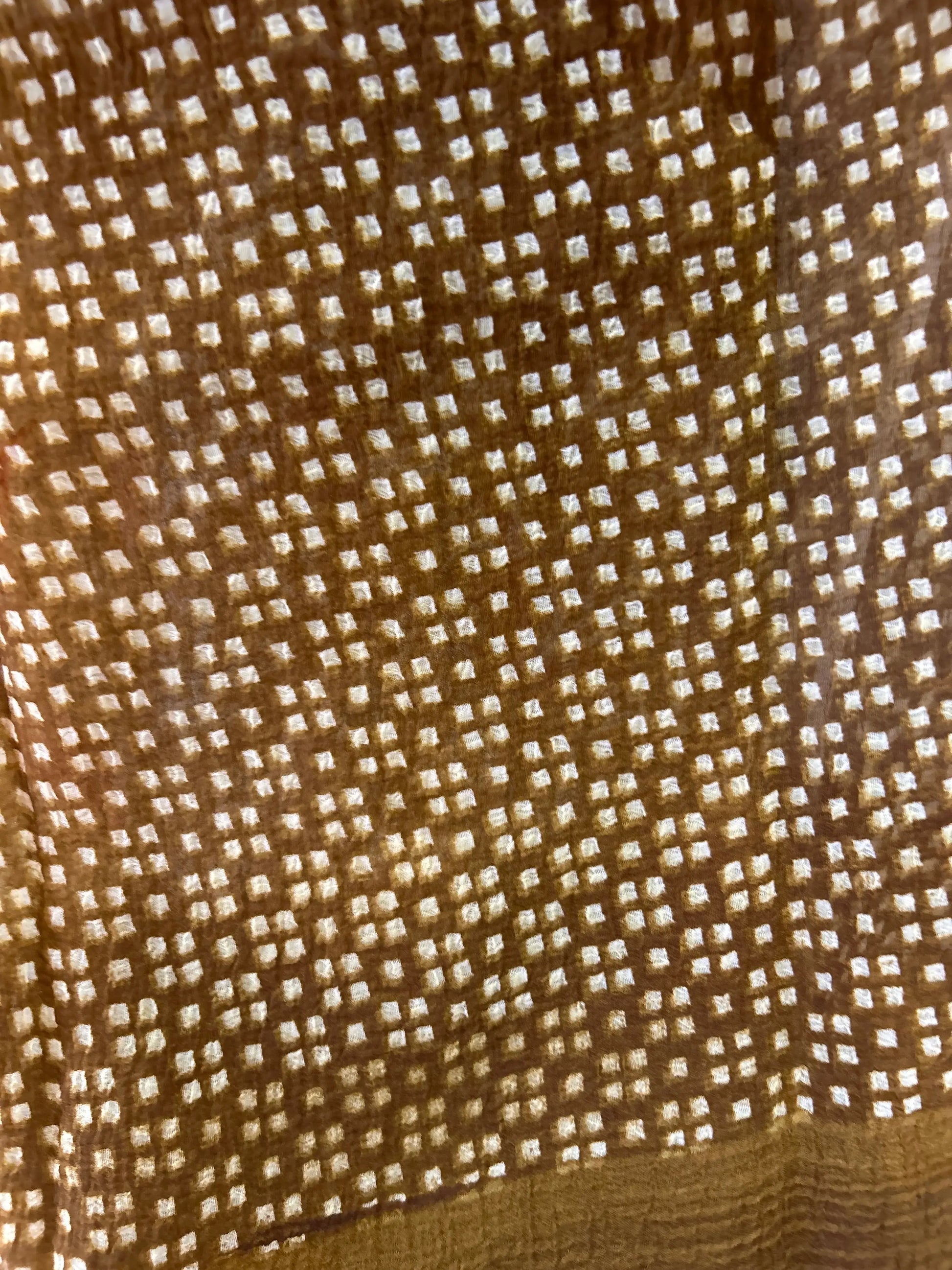 Close-up of a textured brown fabric with a subtle pattern